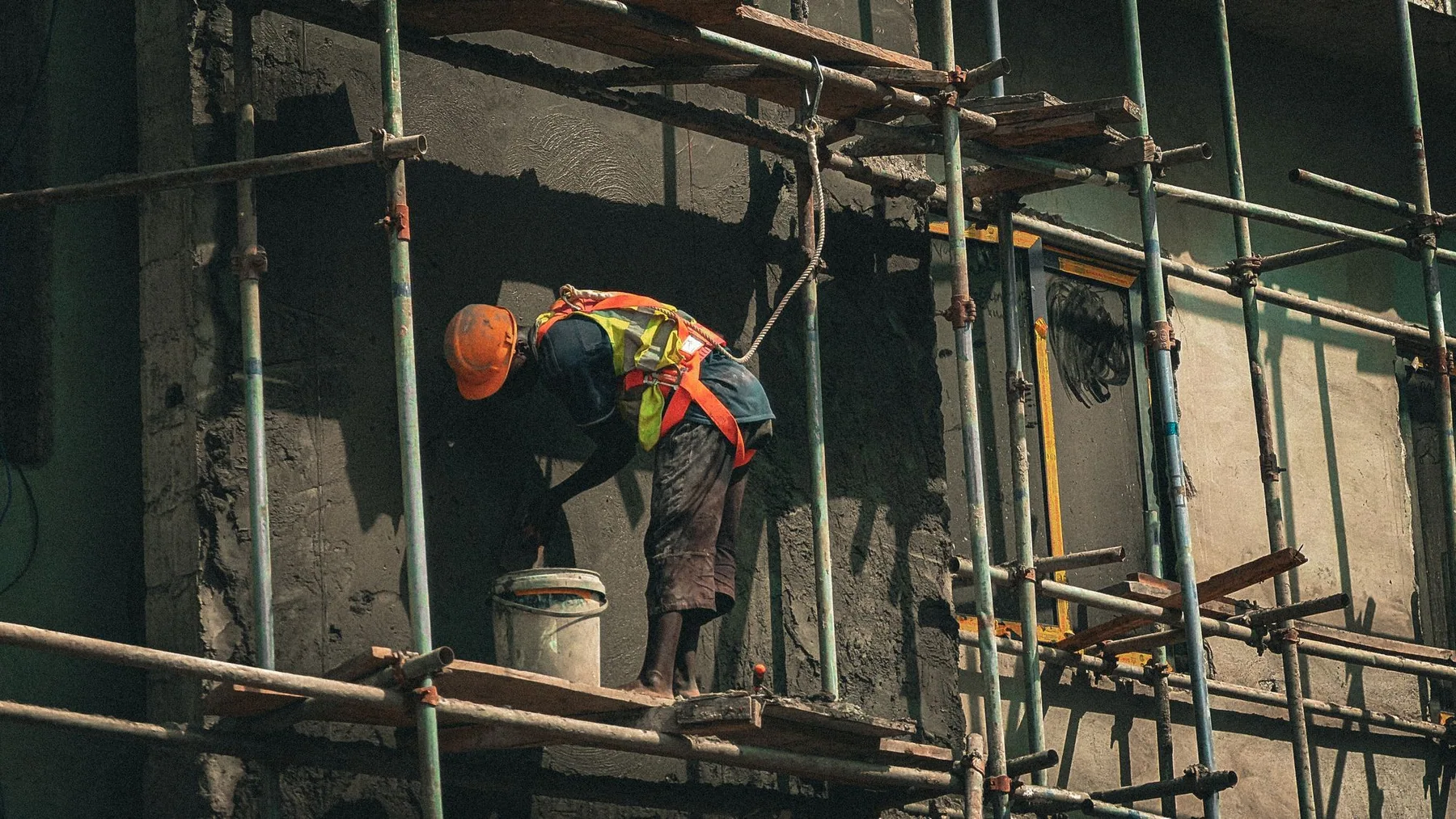 Ouvrier travaillant sur un échafaudage devant une façade