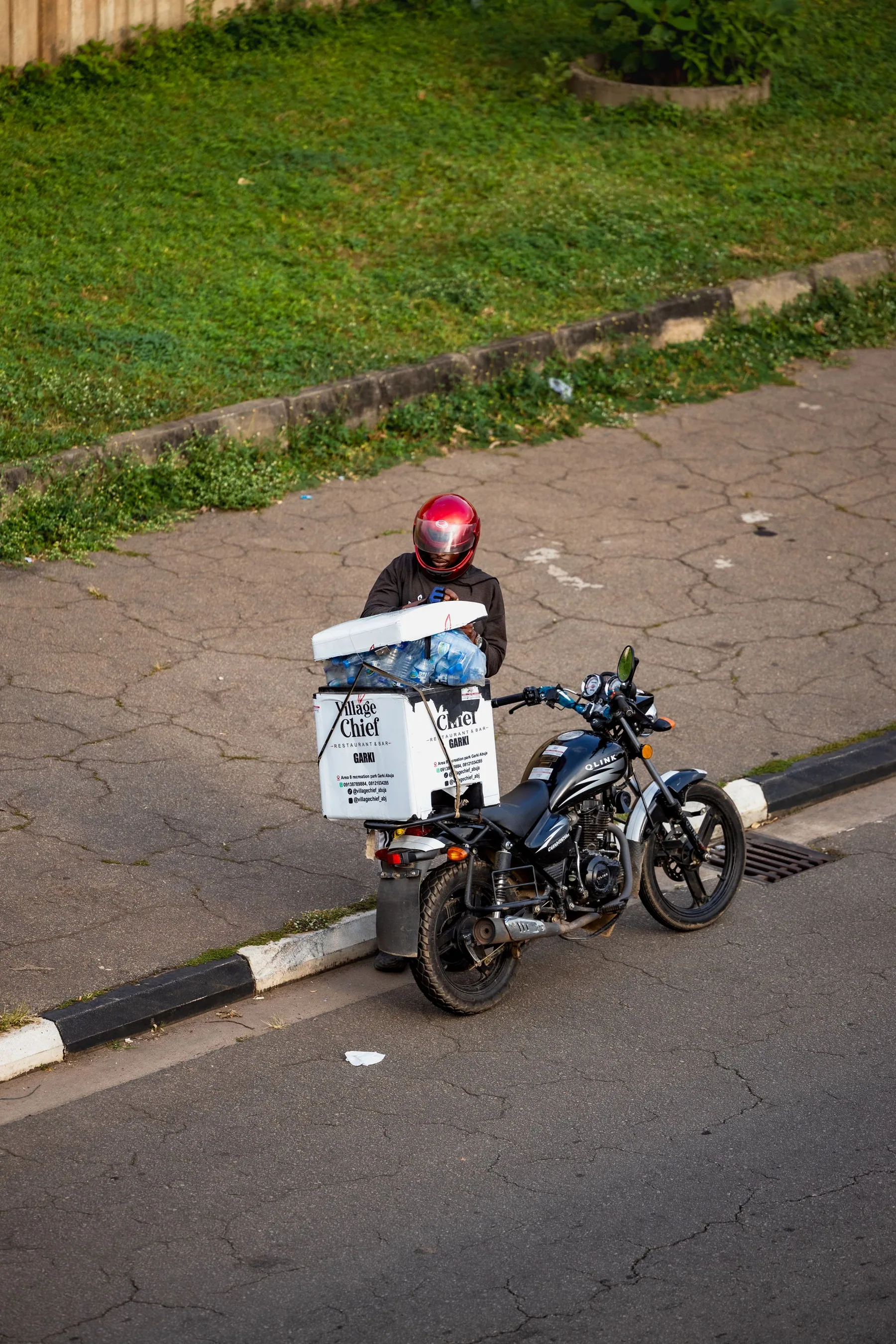 Livreur à moto avec une caisse de livraison, en ville