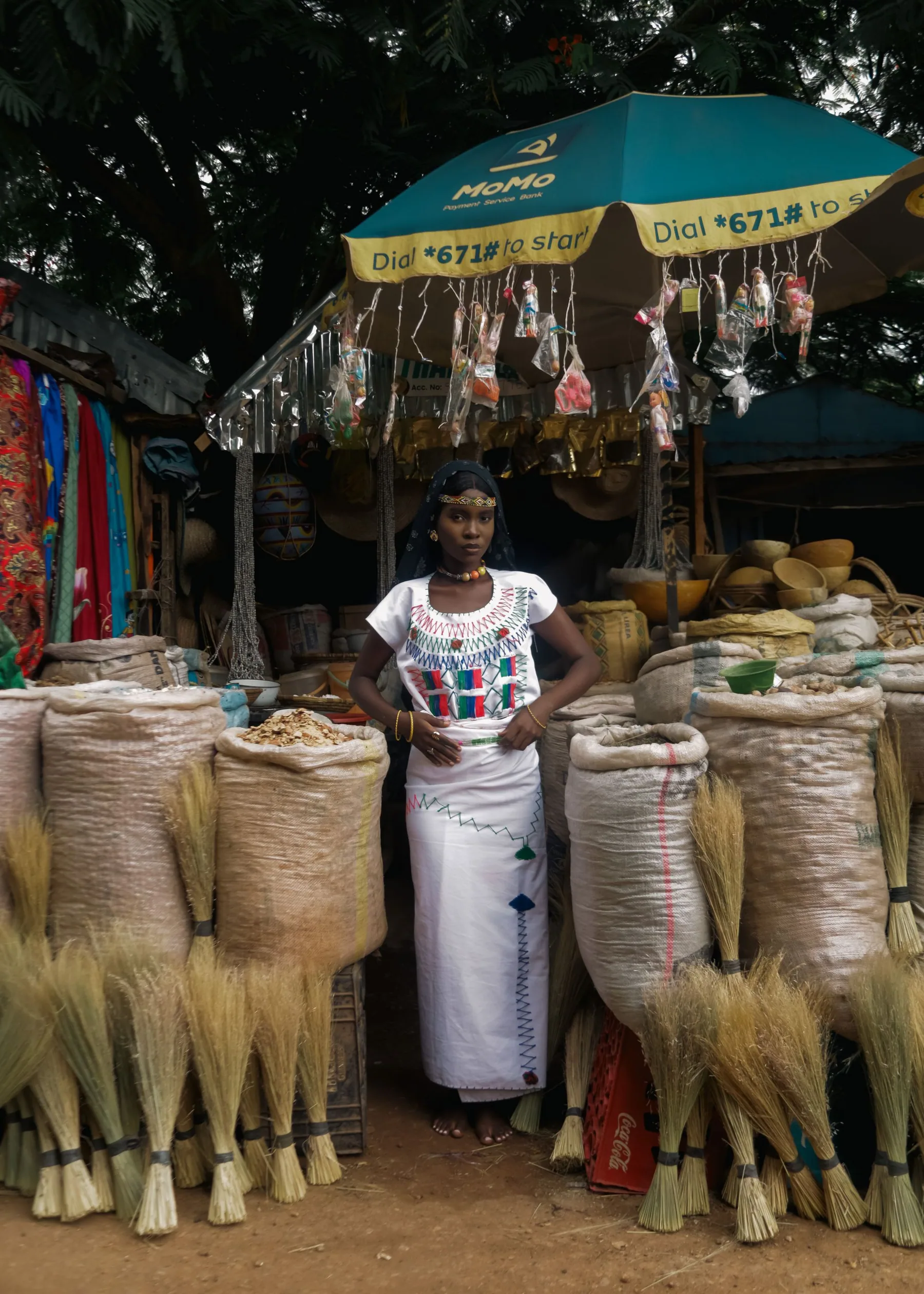 Commerçante entourée de sacs de céréales sur un marché
