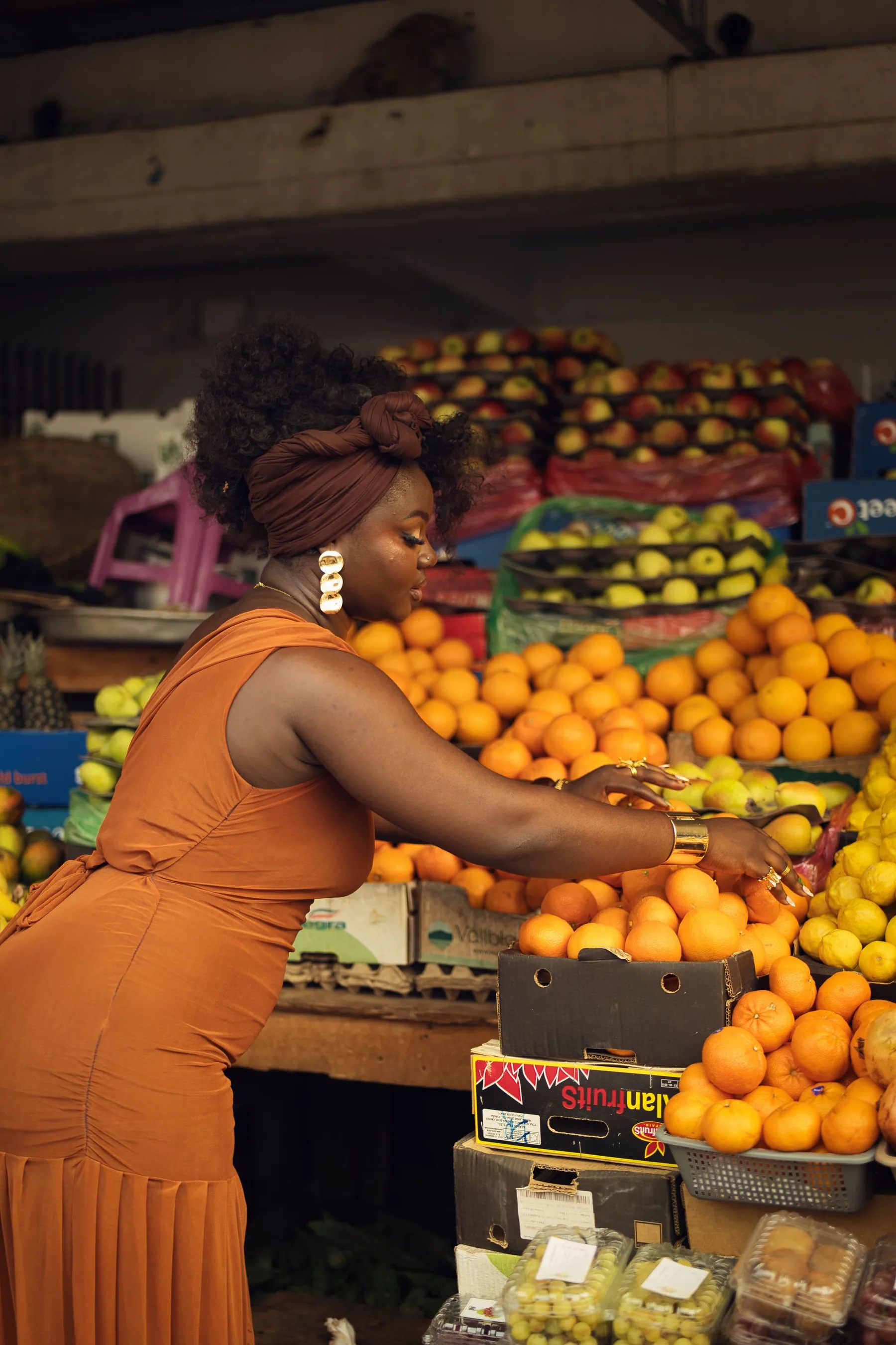 Vendeuse de fruits arrangeant des oranges sur son étal de marché