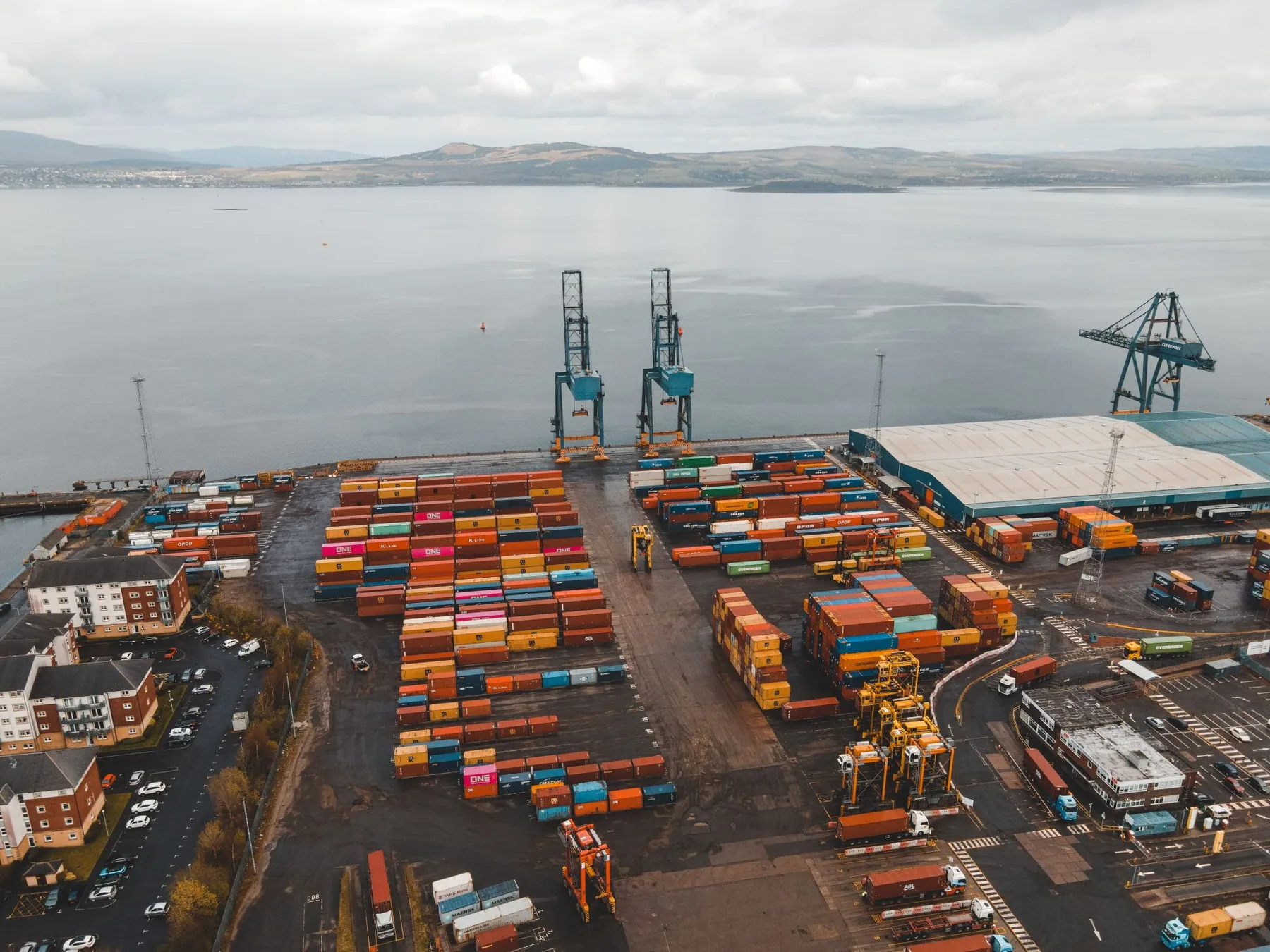Port de conteneurs vu du ciel, grues et piles de conteneurs colorés