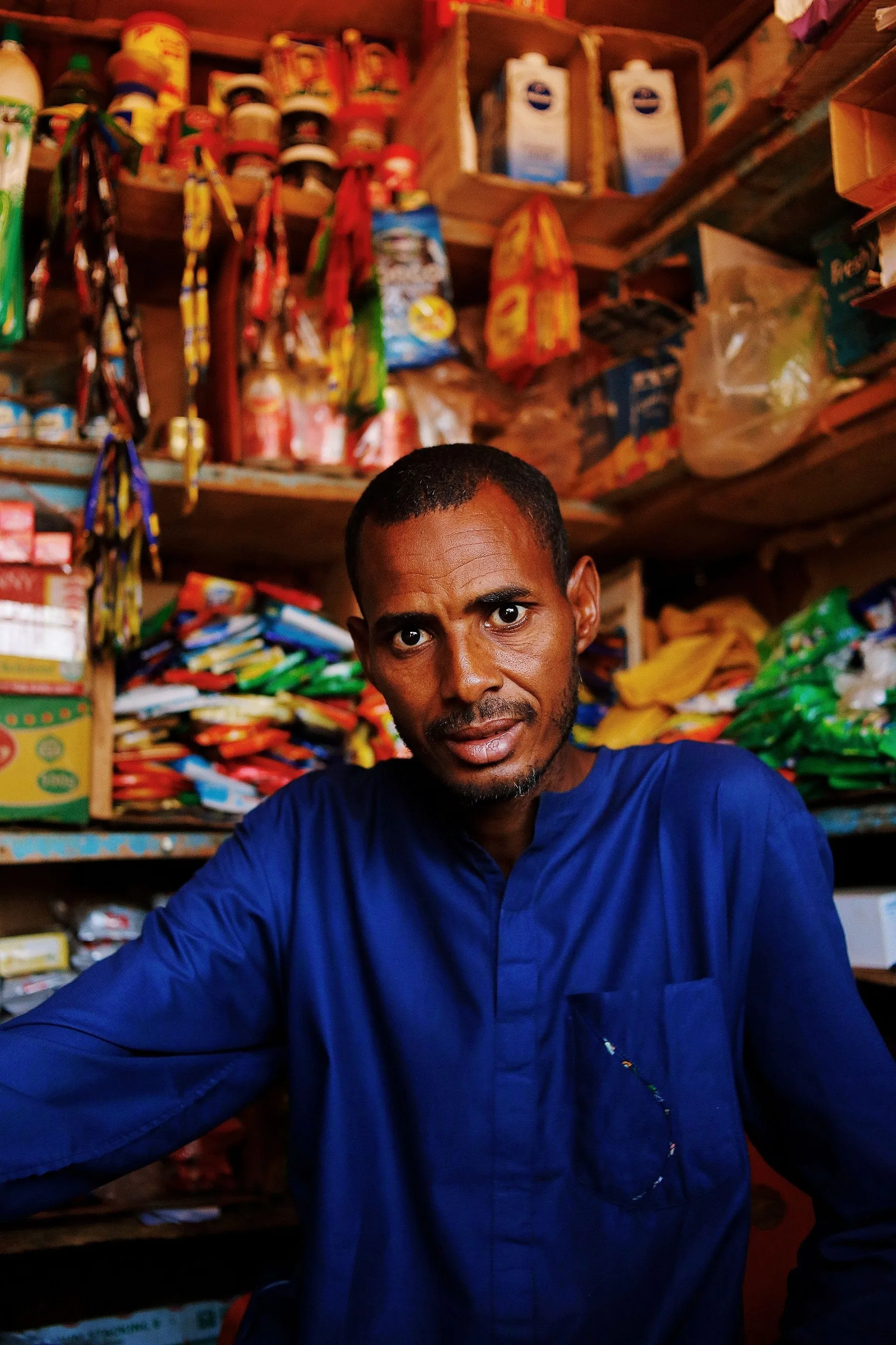 Commerçant en chemise bleue dans sa boutique
