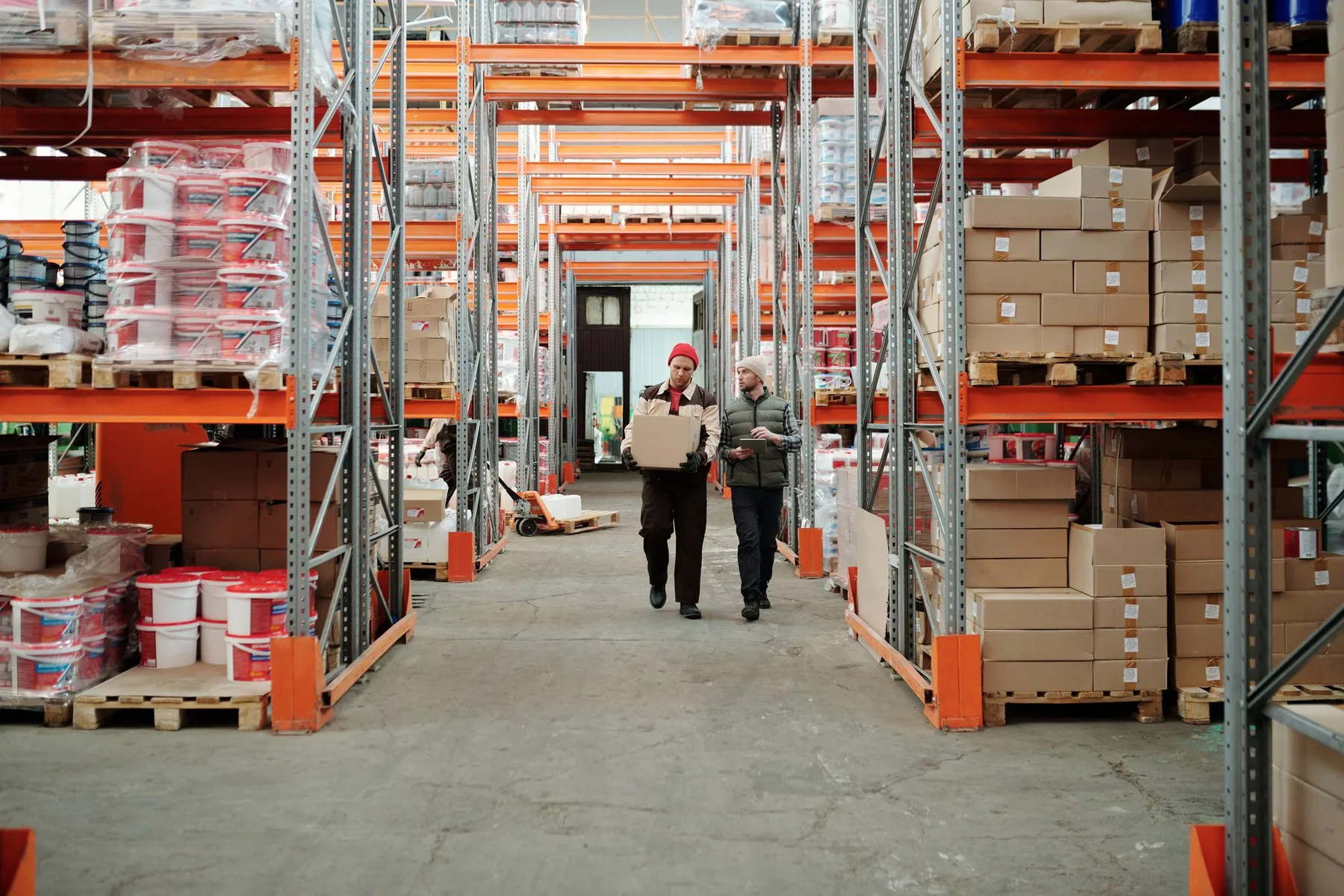 Équipe dans une allée d’entrepôt entre des rayonnages de marchandises